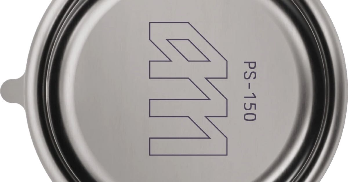 Close-up of the circular PrimeSwitch PS-150 relay device in brushed metal, Atomic Machines logo and 'PS-150' marking visible