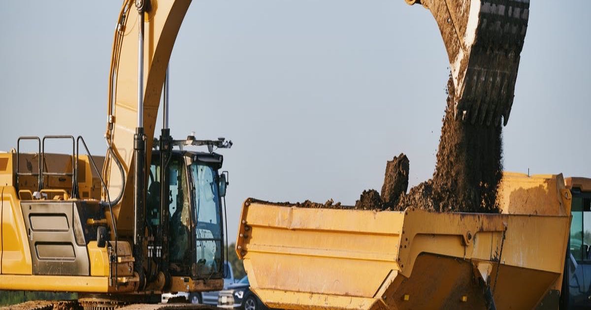 An autonomous excavator fitted with Bedrock Robotics' AI system operating on a commercial construction site.