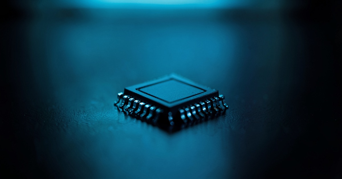 A single advanced AI GPU processor resting on a dark reflective surface under moody blue lighting, no text or logos visible