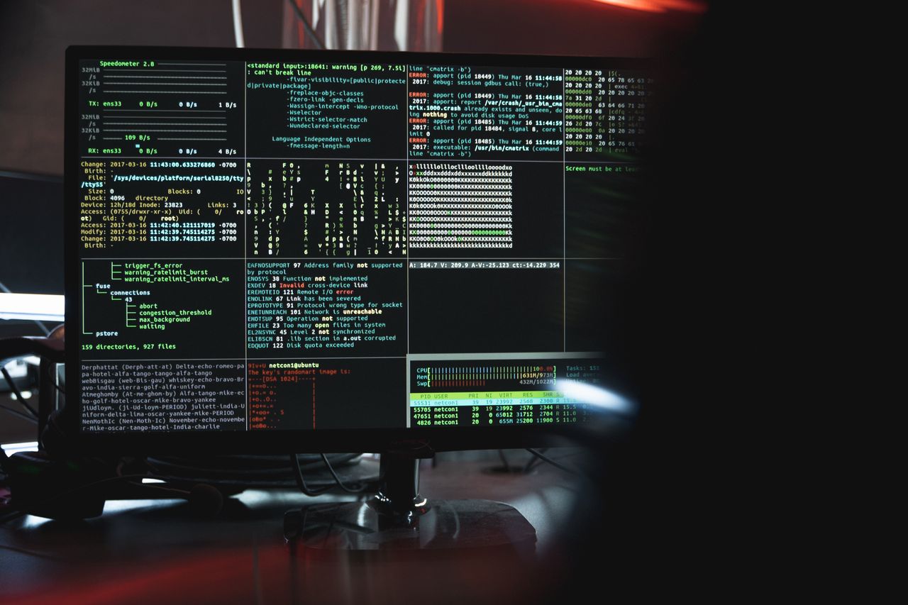 A corporate office with Microsoft Teams on screen showing a security alert, dramatic overhead lighting, photojournalistic