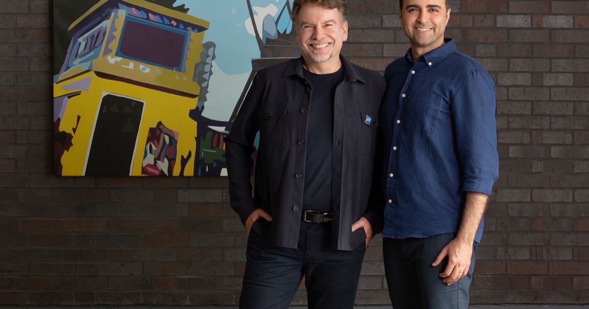Dynamic Creatures co-founders Marc Theermann and Farbod Farshidian standing side by side in front of a colourful mural