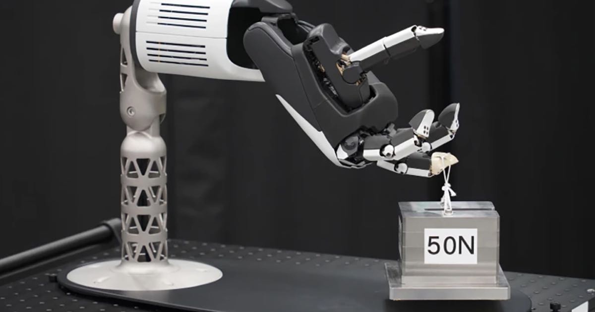 A four-fingered robotic hand grasping a small screw between its thumb and index finger, demonstrating Honda's dexterous manipulation system for industrial assembly tasks.