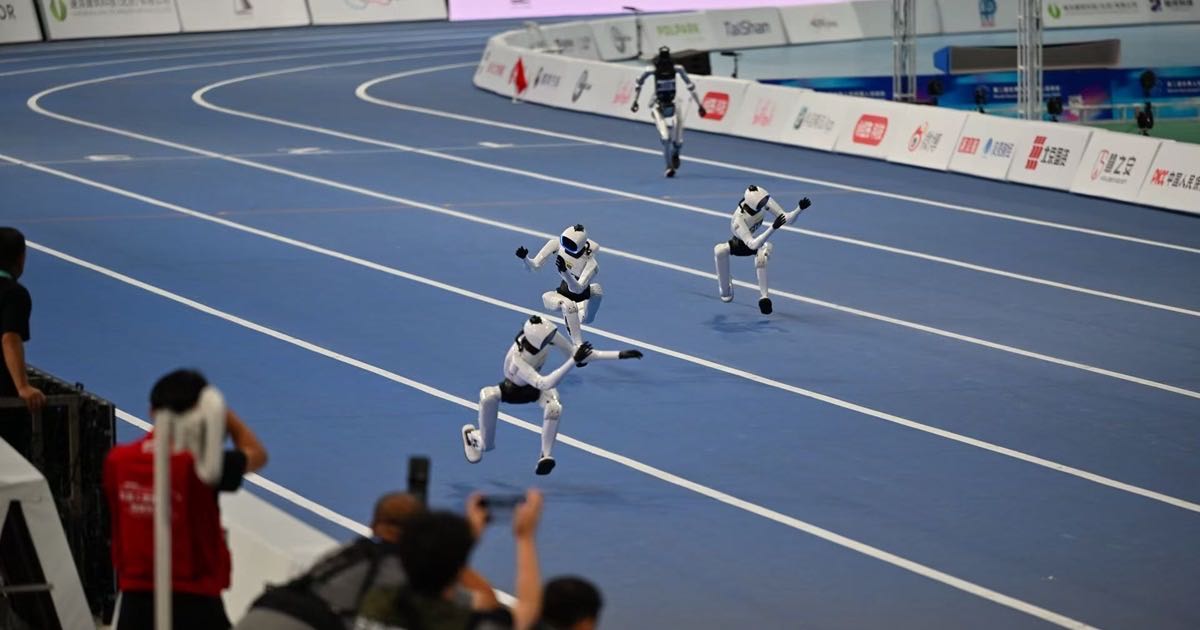 Humanoid robots competing on the track at the National Speed Skating Oval in Beijing during the 2026 World Humanoid Robot Games.