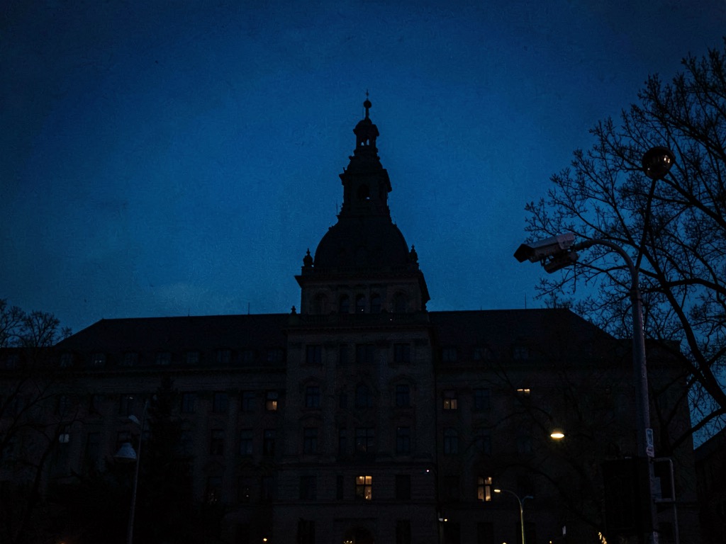 Abstract composition of a government building silhouette under surveillance cameras against a dark blue dawn sky, no text no logos no letters no characters no signs