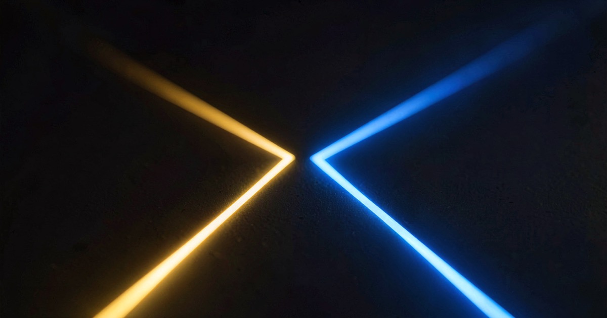 Two converging lines of light on a dark surface, one warm gold and one cool blue, meeting at a vanishing point