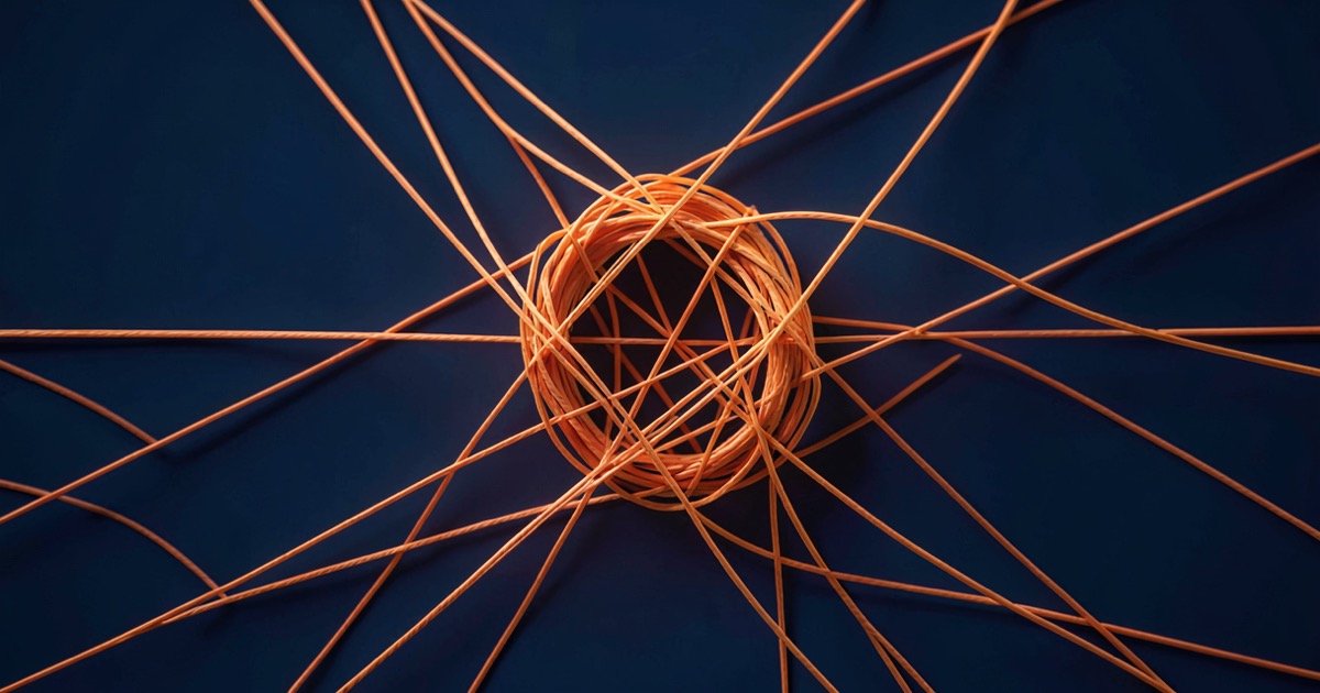 A tangled knot of thin orange threads forming a web against a dark blue background, suggesting a manipulated conversation network.