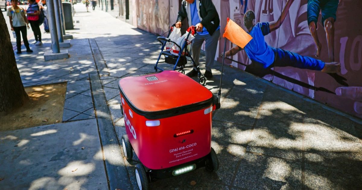 A Coco delivery robot travelling along a sidewalk in downtown San Jose, California