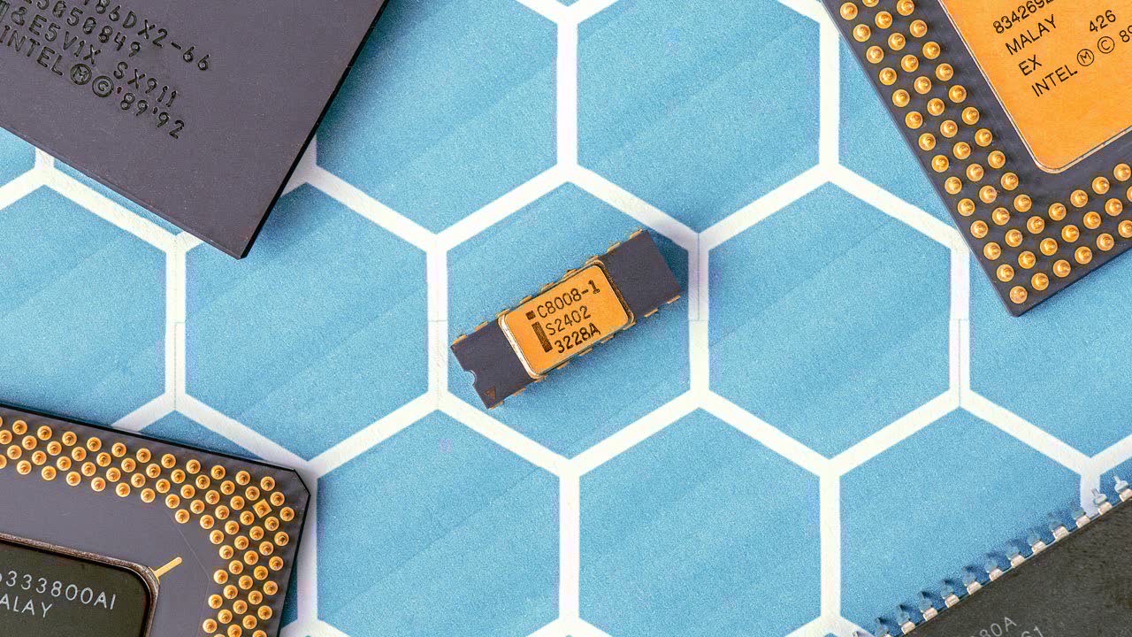 A silicon wafer with RISC-V circuit patterns under bright clean room lighting, blue and gold tones, close-up macro photography