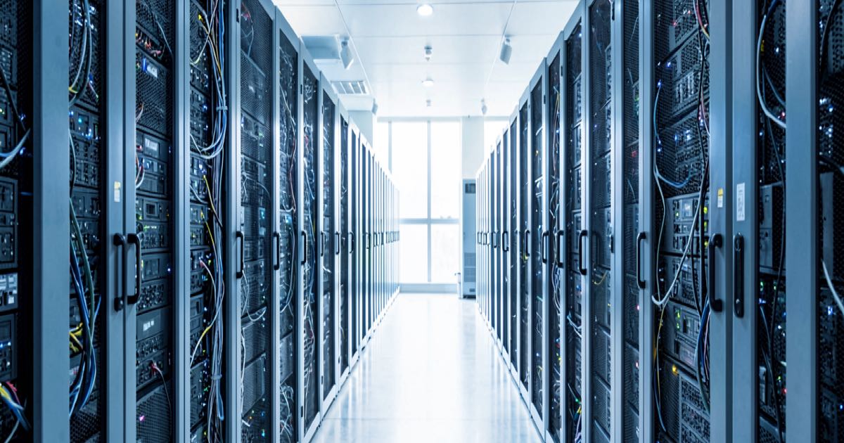 A modern data centre server aisle with rows of GPU racks illuminated in cool blue and white light, representing large-scale AI infrastructure.