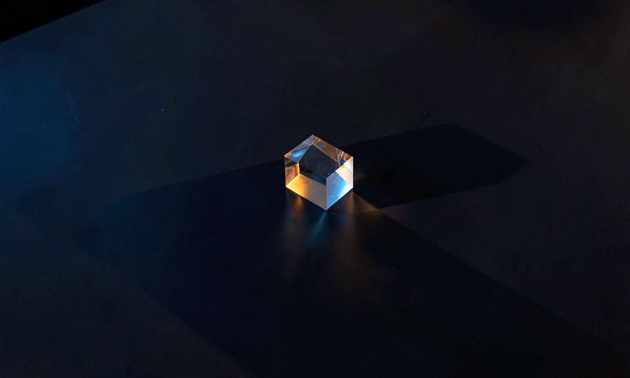 A small glowing geometric shape casting a large shadow on a dark surface, representing a small model producing outsized results.